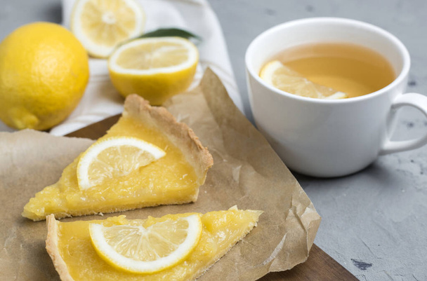 два кусочка лимонного пирога с ломтиком лимона крупным планом на каменном фоне
 - Фото, изображение