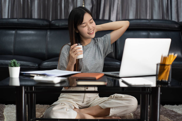 Vonzó fiatal gyönyörű ázsiai nő Vállalkozó vagy szabadúszó dolgozik otthon laptop üzleti jelentések és online kommunikáció a nappaliban kanapé, dolgozik távolról megközelíthető koncepció  - Fotó, kép