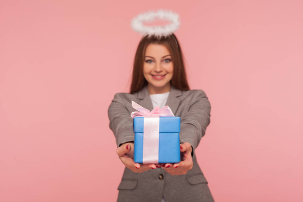 Portrait of beautiful angelic woman with nimbus in business suit giving present to camera, sharing holiday gift, congratulating on birthday anniversary, Valentine's day. indoor studio shot, isolated - Φωτογραφία, εικόνα