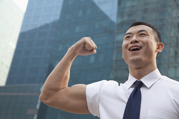 Young businessman flexing muscle - Photo, Image