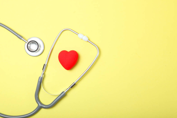 Stethoskop und Herz auf farbigem Hintergrund. Gesundheit, Medizin - Foto, Bild