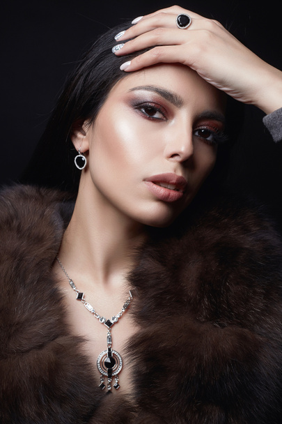 Beautiful arabian Girl in Jewelry and Fur. Beauty Woman in Luxury Fur. Make-up and accessories - Photo, Image