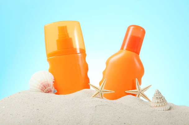 sable, coquillages, étoiles de mer et crème solaire sur fond bleu. Protection de la peau contre le soleil
. - Photo, image