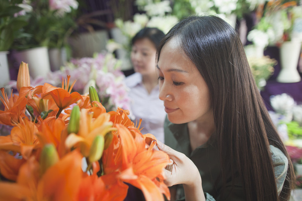 Mujeres mirando flores en floristería
 - Foto, imagen