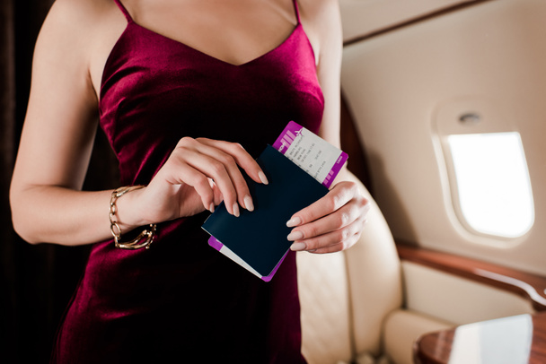 cropped view of sexy woman in elegant dress holding passport and air ticket - Φωτογραφία, εικόνα