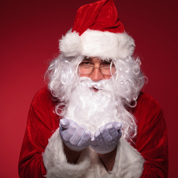 santa claus is holding something on his hands - Foto, Imagen