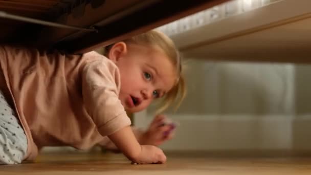 Little girl crawling under bed - Footage, Video