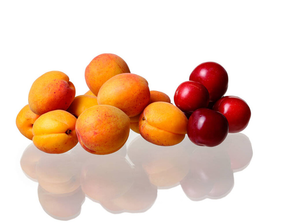 Свіжі абрикоси і сливи ізольовані на білому тлі. концепція свіжих фруктів та органічних продуктів
 - Фото, зображення