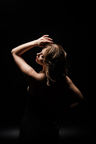 sensual, elegant woman posing with closed eyes on black background - Photo, image