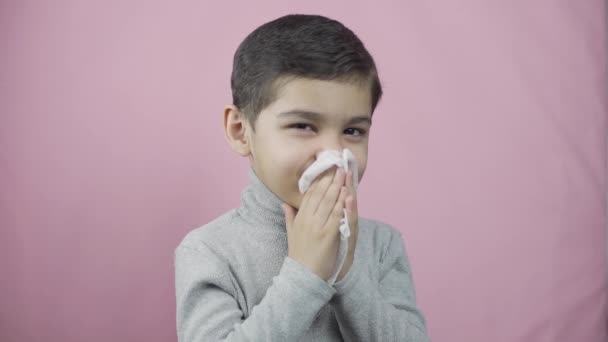 鼻を吹いている男の子。咳をする病気の子供はくしゃみをする - 映像、動画