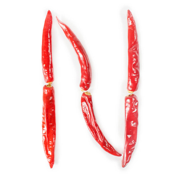Letter N gemaakt van rode hete chili pepers. Geïsoleerd op witte achtergrond - Foto, afbeelding