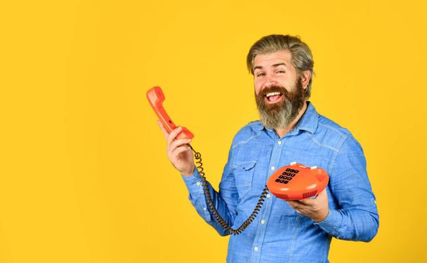 hello 80s. Man with moustache holding vintage phone. vintage communication device. Businessman talking on vintage phone in office. agile business. vintage stationary telephone. some unique creations - Фото, изображение