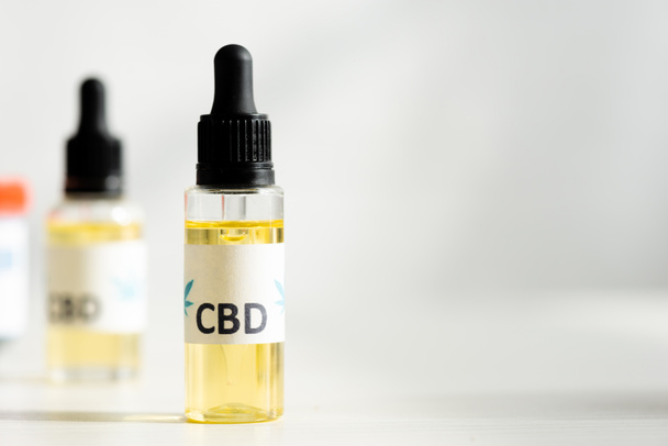 selective focus of bottle with oil and cbd lettering on table  - Foto, Imagem