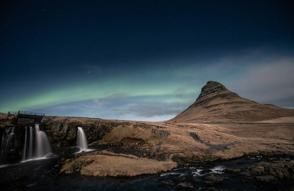 Northern lights aurora borealis over kirkjufell waterfall in Iceland - Photo, Image