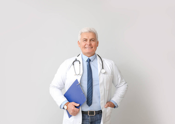 Portrét mužského lékaře na šedém pozadí - Fotografie, Obrázek