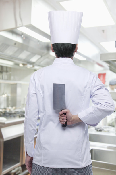 Chef con cuchillo a sus espaldas
 - Foto, Imagen