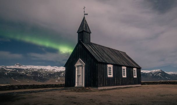 Kuzey ışıkları İzlanda 'daki siyah kilisesinin üzerinde aurora borealis. - Fotoğraf, Görsel