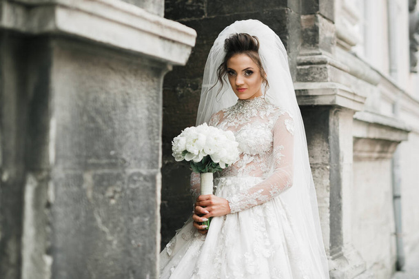 Portrait of stunning bride with long hair posing with great bouquet - Zdjęcie, obraz