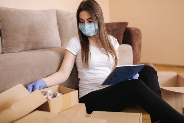 Femme en quarantaine portant un masque de protection à la maison et achetant en ligne. Concept de coronavirus. Restez à la maison
 - Photo, image