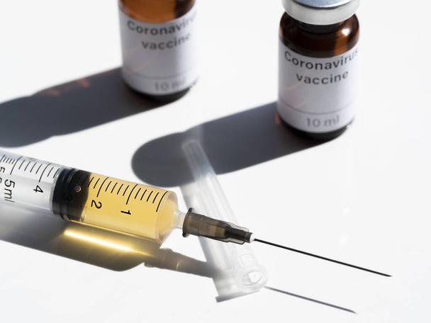In this photo illustration two vials labelled Coronavirus vaccine and syringe are seen on display. The world is anxiously awaiting for a vaccine against coronavirus.  - Foto, Bild