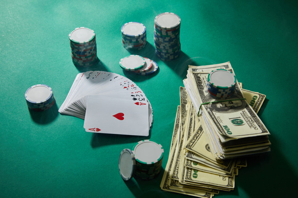 Vue grand angle des cartes à jouer, des jetons de casino et des billets en dollars sur fond vert
 - Photo, image