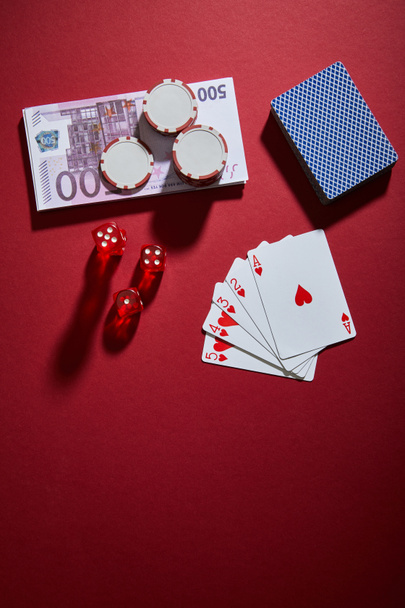 Horní pohled na hrací karty, kostky, žetony kasina a bankovky na červené - Fotografie, Obrázek