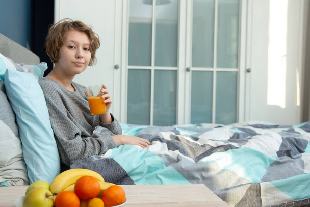 lány pihen a hálószobában, és iszik narancslevet - Fotó, kép
