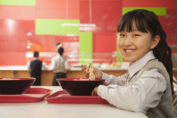 iskola lány étkezési tésztával - Fotó, kép