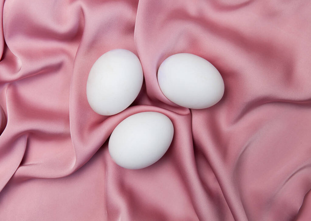 Creative Easter beige and pink background with white eggs. Easter holiday minimal concept. - Valokuva, kuva