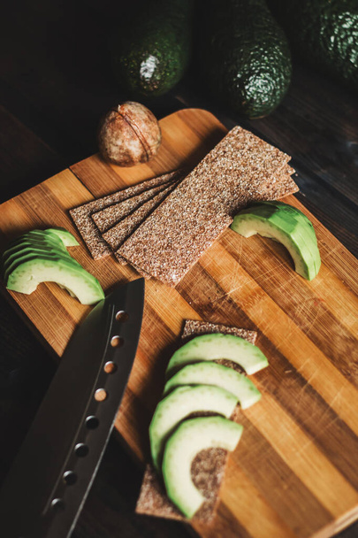 Avocado and bread on a wooden background - Foto, afbeelding