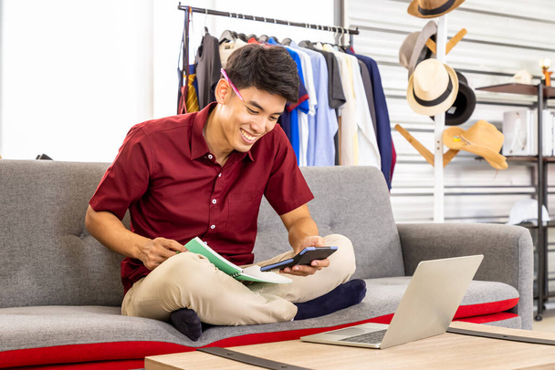 Young Asian male online merchant freelance blogger is working business at home with laptop. Social media, Influencer, and online shopping concept. - Foto, Imagem