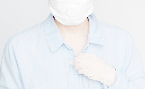 Body in blue shirt, protective mask and hand in white glove, theme of hygiene and protection against virus, coronavirus, covid-19 - 写真・画像
