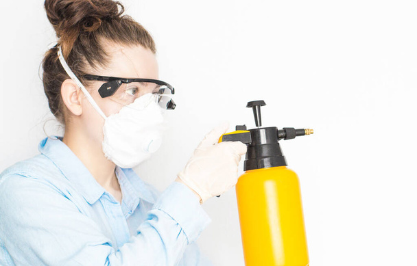 Woman in protective mask and glasses with a spray, theme of hygiene and protection against coronavirus, covid-19 - Φωτογραφία, εικόνα
