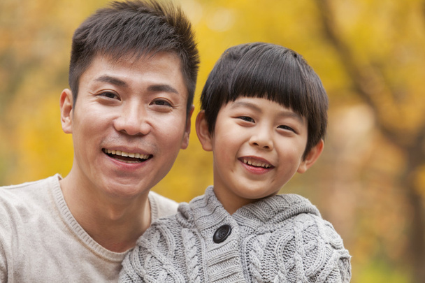 Ojciec i syn uśmiechający się w parku w jesieni - Zdjęcie, obraz