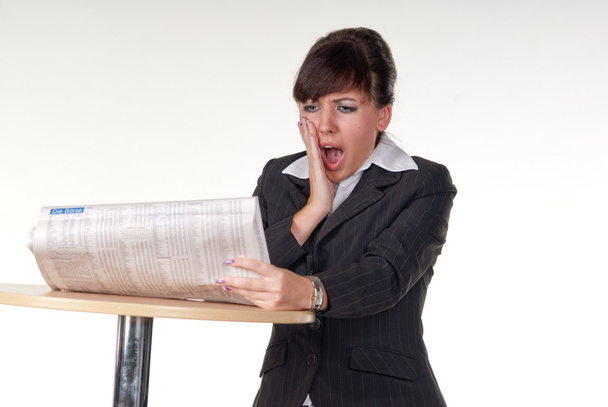 eine junge Geschäftsfrau liest Zeitung und ist überrascht - Foto, Bild