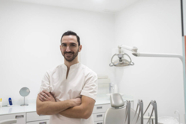 Portrait of a smiling doctor male posing in an dentist room - 写真・画像