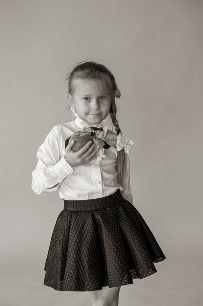 шестирічна дівчинка в білій футболці ізольована на синьому студійному фоні, досить європейський зовнішній вигляд дитина позує в приміщенні посміхненим поглядом на камеру, концепцією покоління Z. Дівчина школярка на синьому фоні
 - Фото, зображення