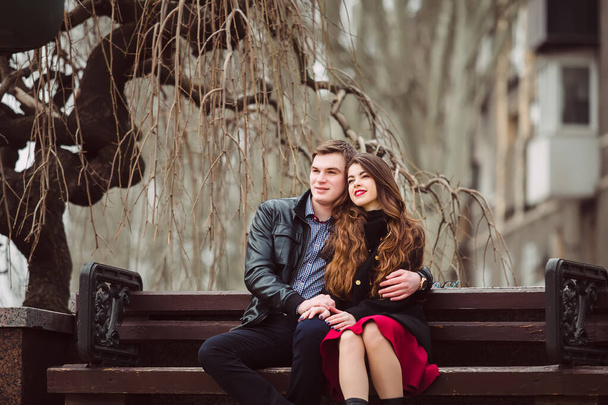 Loving couple sitting on a bench - Fotó, kép