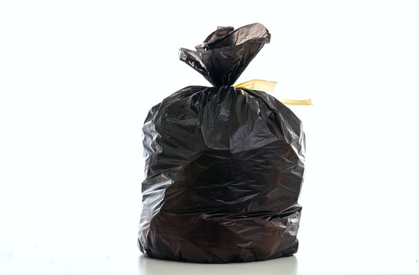 Müll, Müllsack schwarze Farbe voll mit Abfall und gebunden isoliert vor weißem Hintergrund - Foto, Bild