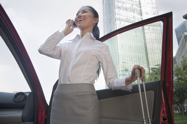 Young Businesswoman outside of her car talking on the phone - Фото, изображение