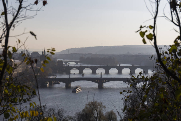 кам'яні мости Праги на заході сонця перетинають річку Влтаву з холодною і темною водою, європейською архітектурою. - Фото, зображення