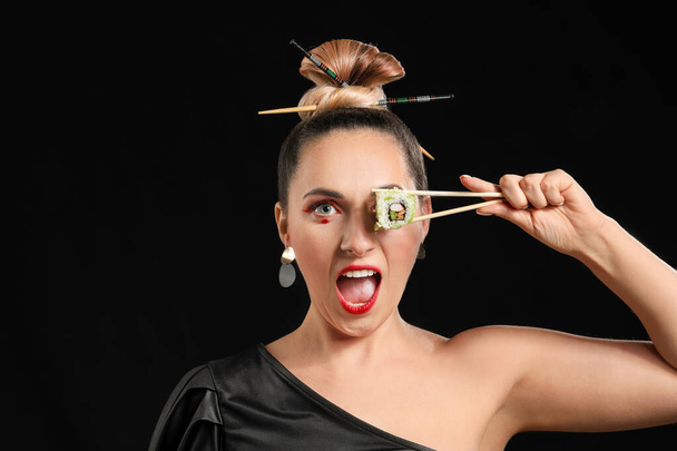 Beautiful woman with tasty sushi on dark background - Foto, afbeelding