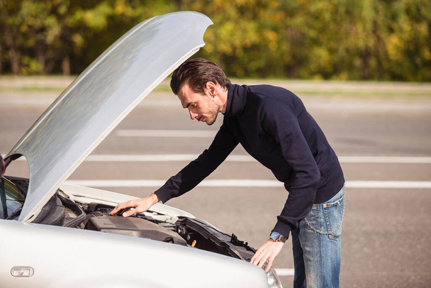 A man tries to repair the car on the road  - Photo, Image