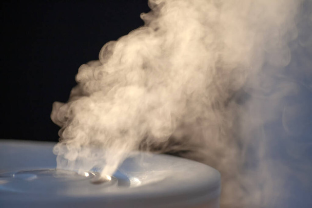 Humidifier spreading steam in evening light - Foto, Imagen