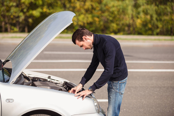 A man tries to repair the car on the road  - Φωτογραφία, εικόνα