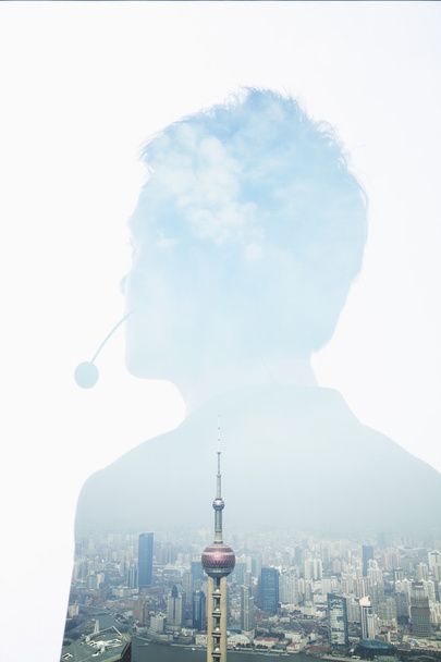 Doppia esposizione di giovane uomo d'affari con auricolare e skyline di Shanghai
 - Foto, immagini