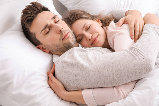 Young couple sleeping in bed - Foto, afbeelding