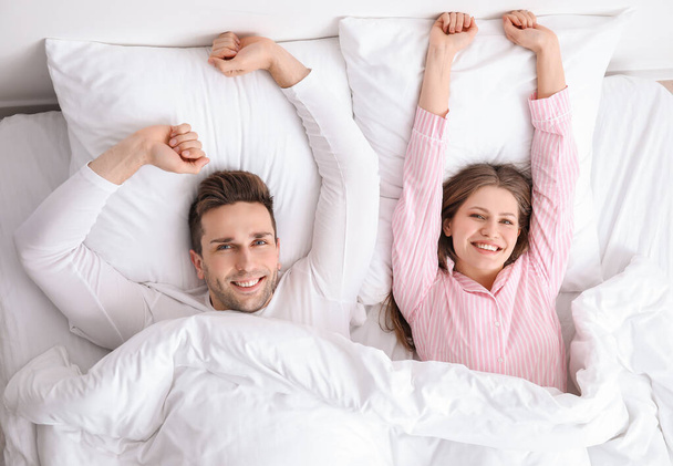 Ochtend van gelukkig jong paar in bed - Foto, afbeelding