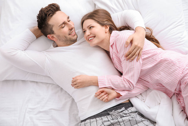 Morning of happy young couple in bed - Фото, изображение