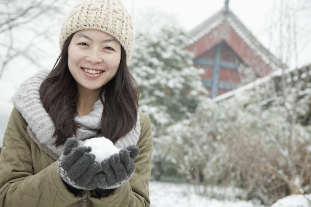 Жінка тримає сніжку в парку
 - Фото, зображення